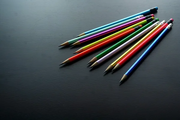 Färgade pennor på ett träbord — Stockfoto