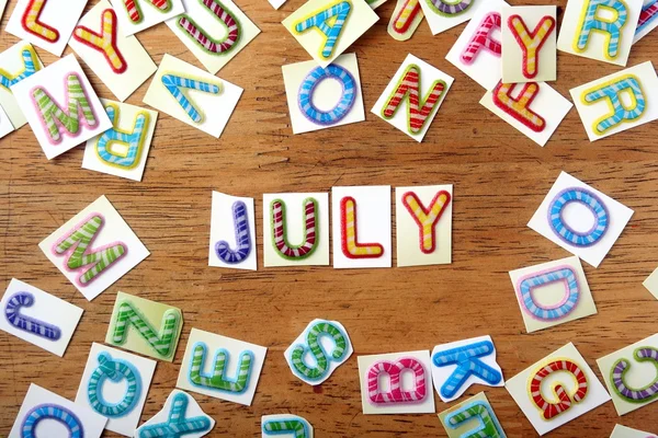 Цветные буквы, написанные как июль — стоковое фото