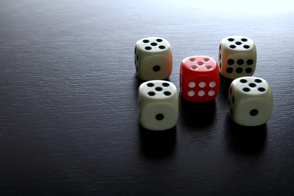 One Red game dice and five white game dice