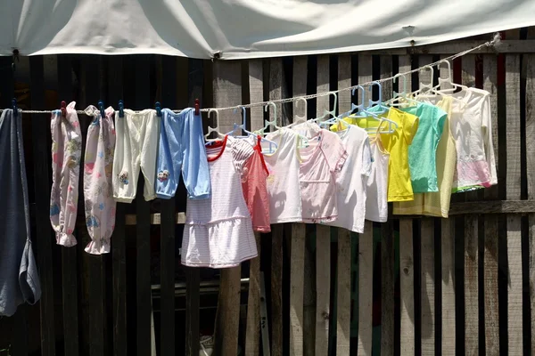 Roupas em uma linha de roupas sendo penduradas para secar — Fotografia de Stock