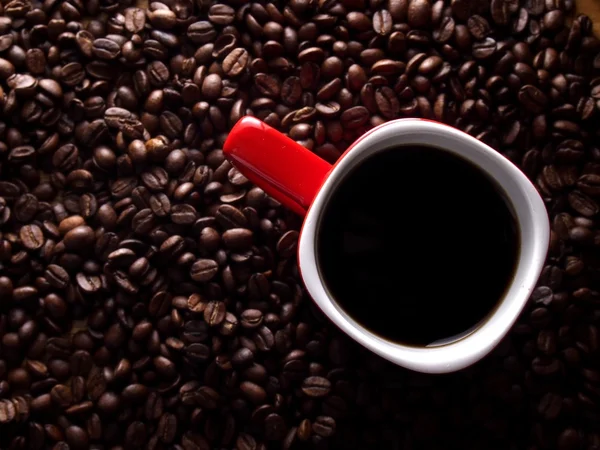 Coffee beans and a red coffee mug