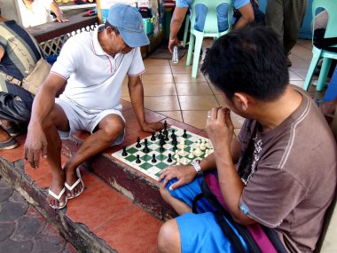 Group of men play the board game chess