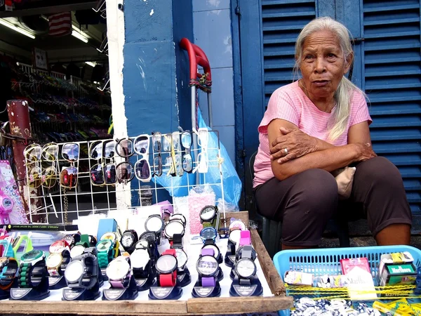 Old lady street vendor sells watches and eyewear — Stok fotoğraf