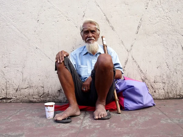 An old man sits on a sidewalk in Antipolo city — Stock Photo, Image