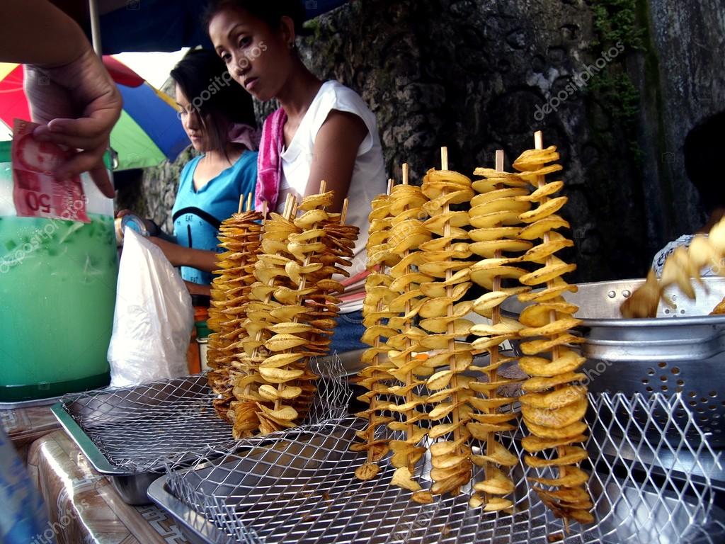 Street vendor sells fried potatoes on a stick Stock Editorial Photo