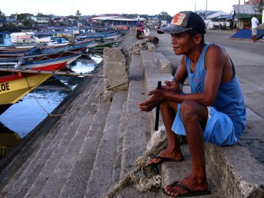 A fisherman rests at a pier before heading out to sea again.