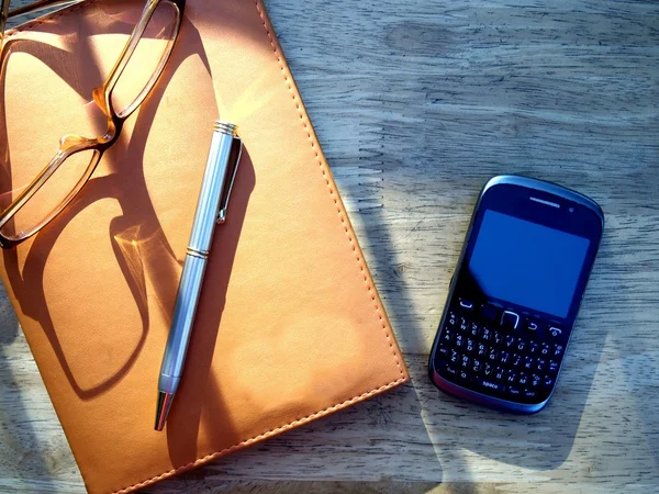 Gözlük, kalem, cep telefonu ve dizüstü