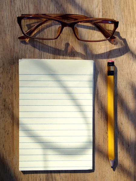 Gafas graduadas, lapicera y bloc de notas — Foto de Stock