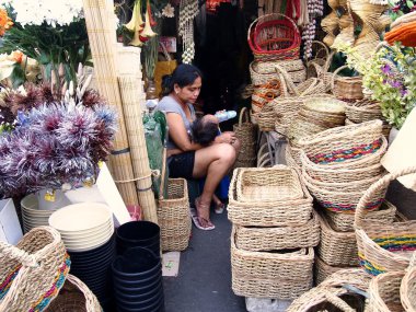 Bir kadın bebeğini Dapitan Pazar onun mağazasında beslemeleri