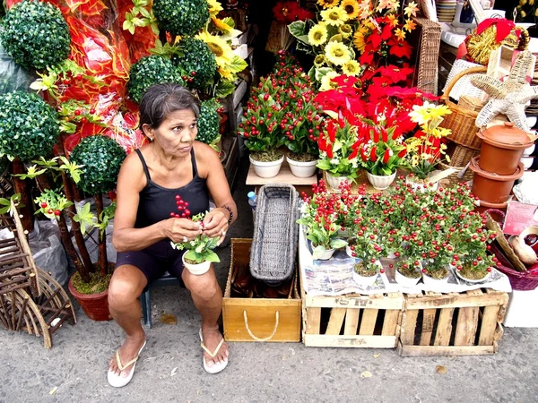 Μια γυναίκα που πωλεί διακοσμητικά πλαστικά φυτά και τα λουλούδια στην αγορά Dapitan — Φωτογραφία Αρχείου