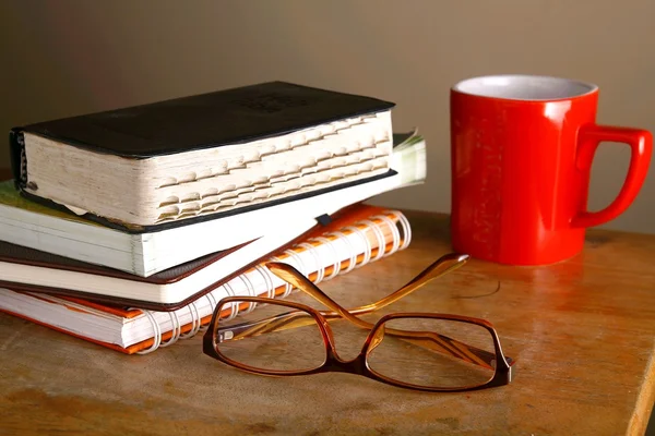 Óculos, caneca de café e pilha de livros — Fotografia de Stock