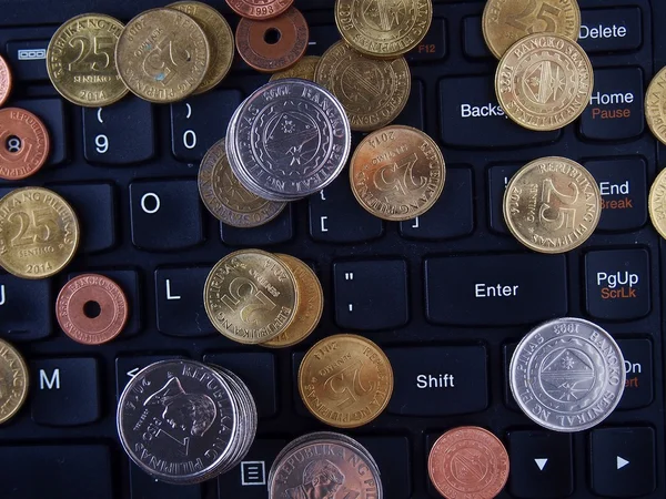 Monedas en el teclado de un ordenador portátil — Foto de Stock