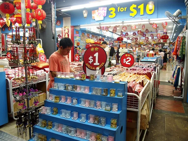 Os turistas escolhem entre uma variedade de produtos de lembrança em uma loja ou loja em Chinatown, Cingapura . — Fotografia de Stock