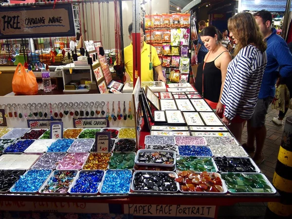 Turister väljer från en mängd olika Souvenirprodukter på en butik eller handla i Chinatown, Singapore. — Stockfoto