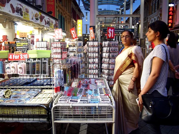 Os turistas escolhem entre uma variedade de produtos de lembrança em uma loja ou loja em Chinatown, Cingapura . — Fotografia de Stock