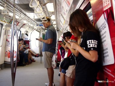 Taşıt veya yolcu Mrt içinde onların akıllı telefon veya cep telefonu zaman geçirmek.