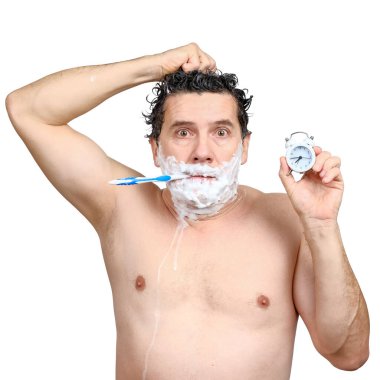 Beyaz adam elinde diş fırçası, başını yıkıyor, çalar saati tutuyor ve geç saatlere kadar çalışıyor.