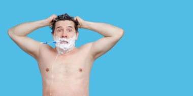 Beyaz adam elinde diş fırçası, başını yıkıyor, doğrudan ve geç bakıyor.