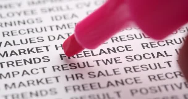 El resaltador rosa marca la palabra freelance. Macro shot, enfoque selectivo — Vídeo de stock