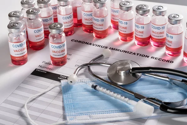 Stetoskop, strzykawka i butelki szklane ze szczepionką do szczepienia COVID-19 — Zdjęcie stockowe