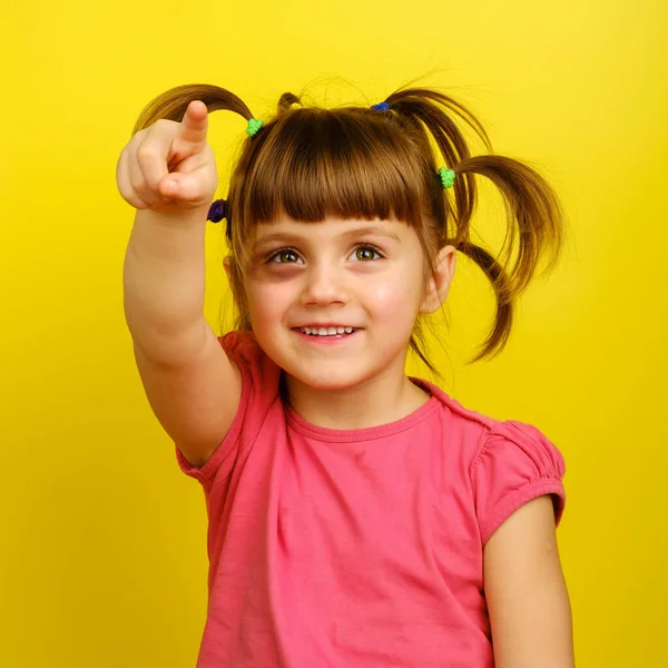 Маленькая белая девочка с косичками и синяками под глазом и указывая вверх — стоковое фото