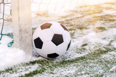 Football ball near soccer goal in winter clipart