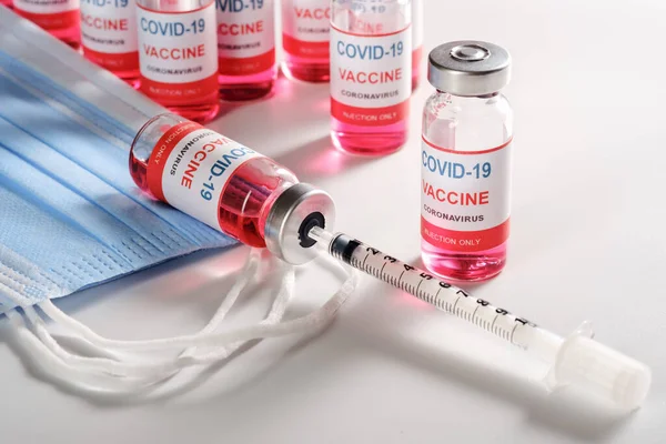 Nowa szczepionka koronawirusowa z maską chirurgiczną i strzykawką — Zdjęcie stockowe