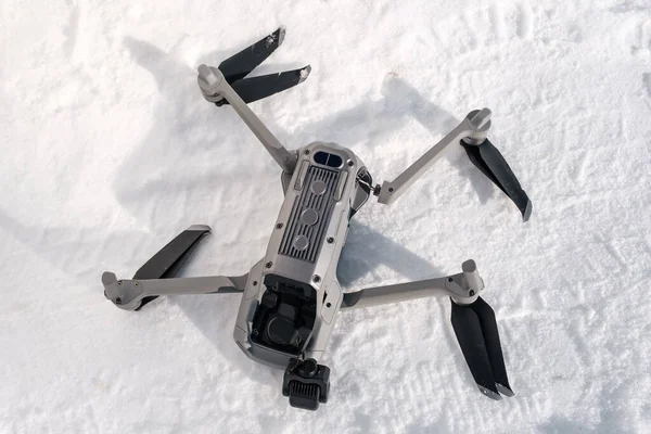 Broken camera and drone arm after crash on snow in winter