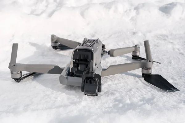 Broken camera and drone arm after crash on snow in winter