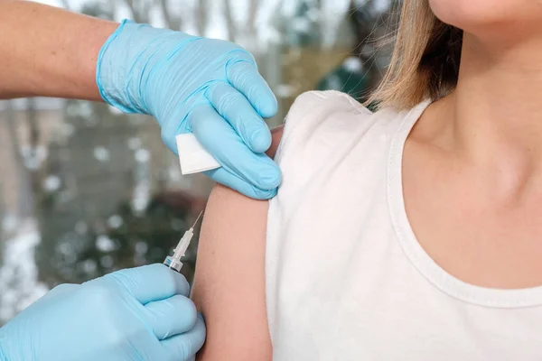 Doctor hands making vaccination in the shoulder of patient