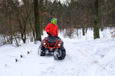 KYIV, UKRAINE - 21 Şubat: Bir adam karlı kış parkında dörtlü bisiklet sürüyor