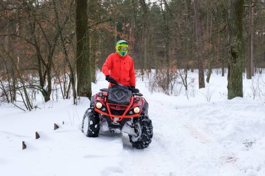 KYIV, UKRAINE - 21 Şubat 2021: Karlı bir kış parkında bir adam dörtlü bisiklet sürüyor