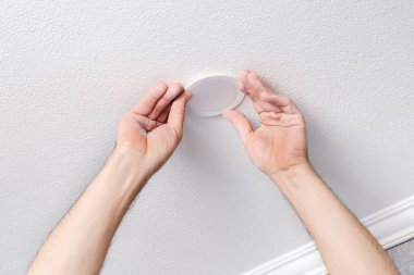 Elektrikçi elleriyle modern LED ampulü onarıyor veya kuruyor