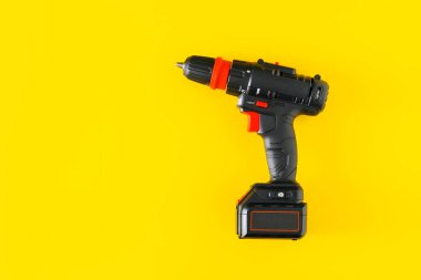 Sarı arkaplandaki el bilgisayarı matkabı.