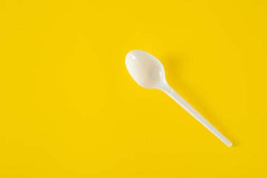 Sarı arka planda plastik kaşık
