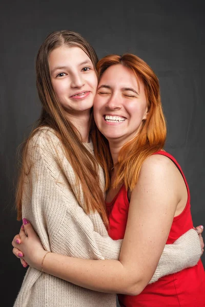Δύο χαμογελαστές αδελφές αγκαλιάστηκαν εσωτερικά και κοιτώντας την κάμερα — Φωτογραφία Αρχείου