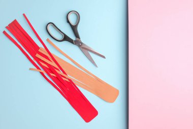 Kinesiology tape and scissors on pink blue background