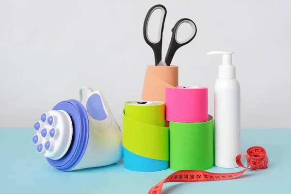 Handheld massager, rolls of kinesiology tape, scissors and antiseptic bottle — Foto de Stock