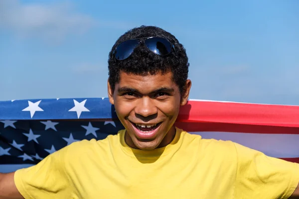 Giovane Uomo Afroamericano Sorridente Guardando Fotocamera Tenendo Orgogliosamente Bandiera Americana — Foto Stock