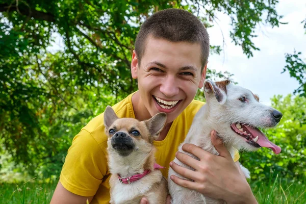 Homem Caucasiano Jovem Abraça Dois Cães Jack Russell Chihuahua Alegremente — Fotografia de Stock