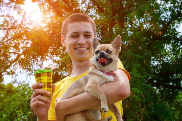 Młody Uśmiechnięty Biały Mężczyzna Trzymający Wynos Psa Chihuahua Kawę Spacer — Zdjęcie stockowe