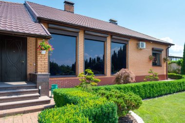 Evin önünde güzel budanmış çalıları olan Avrupa tarzı bir villa ve bahçe. Peyzaj tasarımı. Yüksek kalite fotoğraf