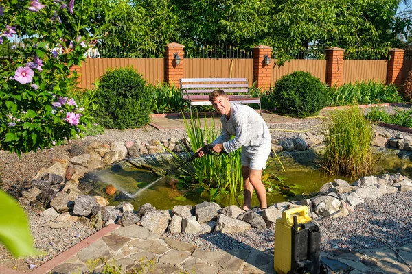 Young Smiling Caucasian Man Cleans Artificial Garden Pond Bottom High — Stock Photo, Image