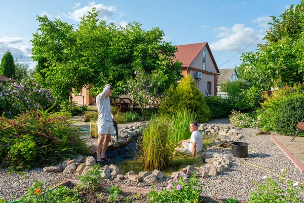 Mature Father Young Adult Son Cleaning Artificial Garden Pond Bottom — Stock Photo, Image