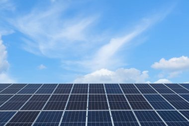 Mavi gökyüzünün altındaki bir güneş çiftliğinde sıra sıra güneş panelleri. Güneş enerjisi santrali, ekolojik alternatif bir elektrik kaynağı. Ön görünüm, boşluğu kopyala