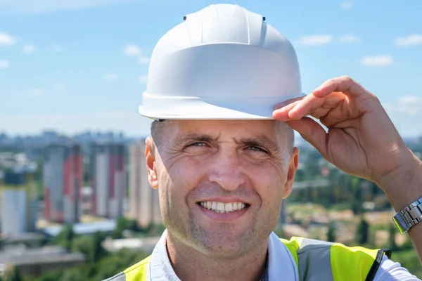Pewny siebie inżynier budowlany w twardej czapce i z kurtką na ramionach — Zdjęcie stockowe