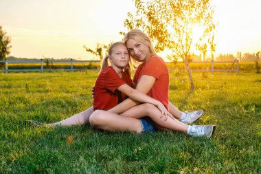 Anne ve kızı akşamları çimenlerde dinleniyorlar.