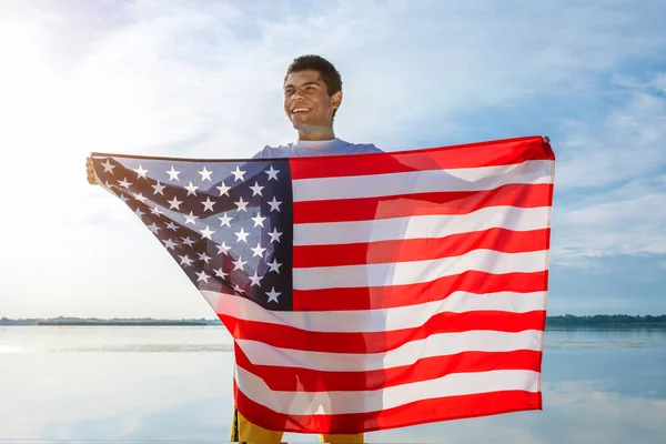 Afroamerikaner schaut weg und hält stolz amerikanische Flagge in der Hand — Stockfoto