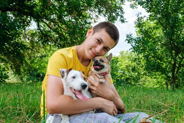 Homem abraça dois cães Jack Russell e um chihuahua e descansando no parque — Fotografia de Stock