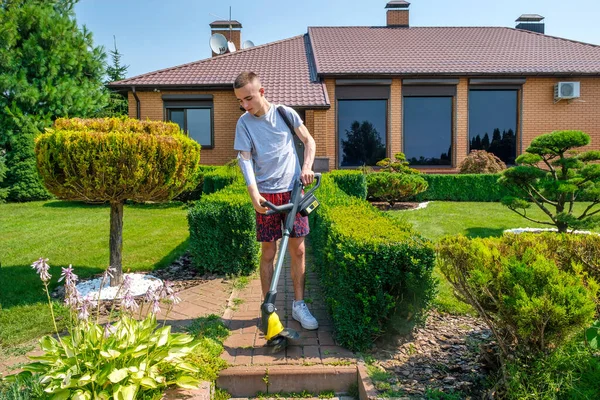 Mężczyzna z amputowaną ręką i protezą usuwającą chwasty na chodniku — Zdjęcie stockowe